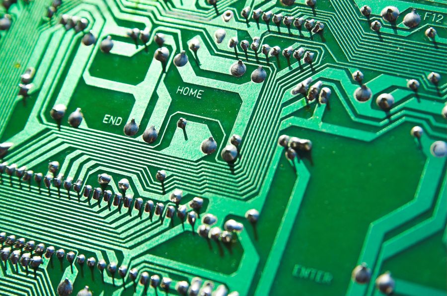 Macro view of green printed circuit board traces and solder joints