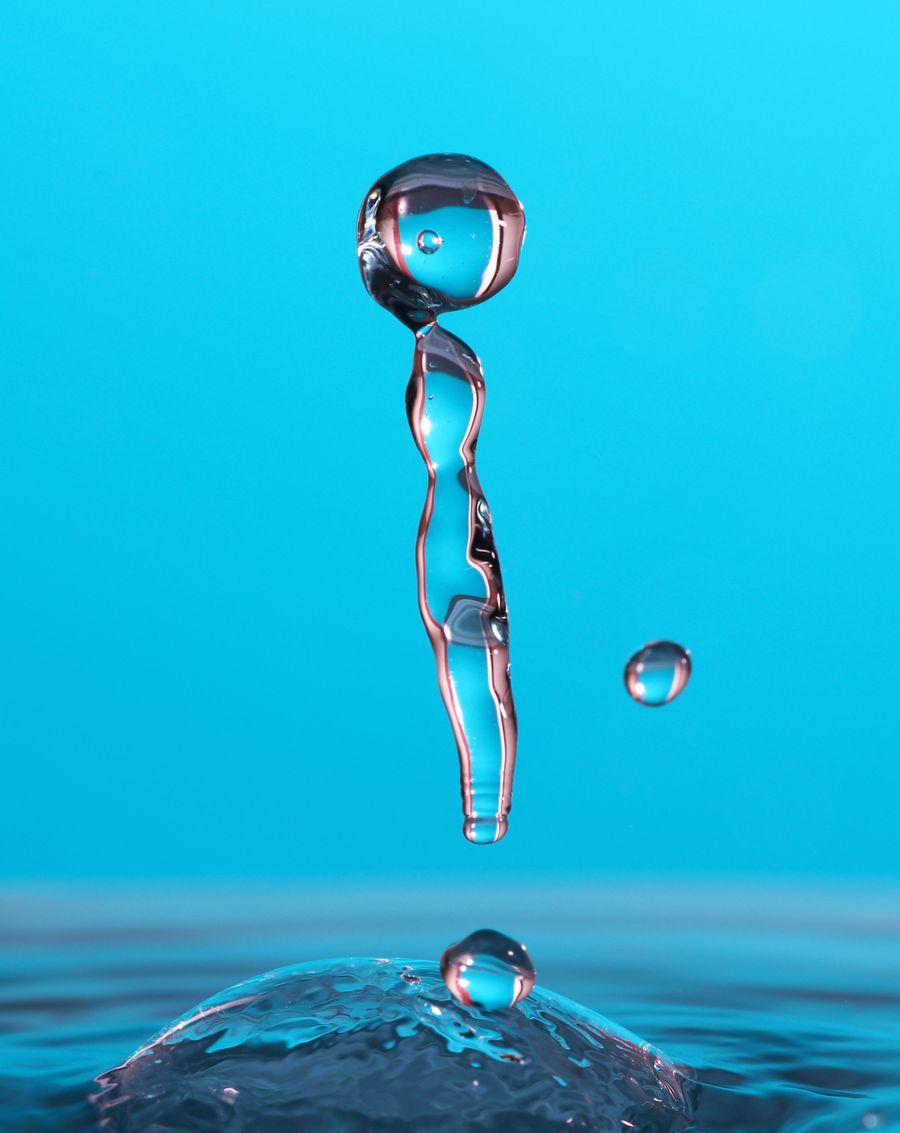 A clear column of pure water rising against a blue background
