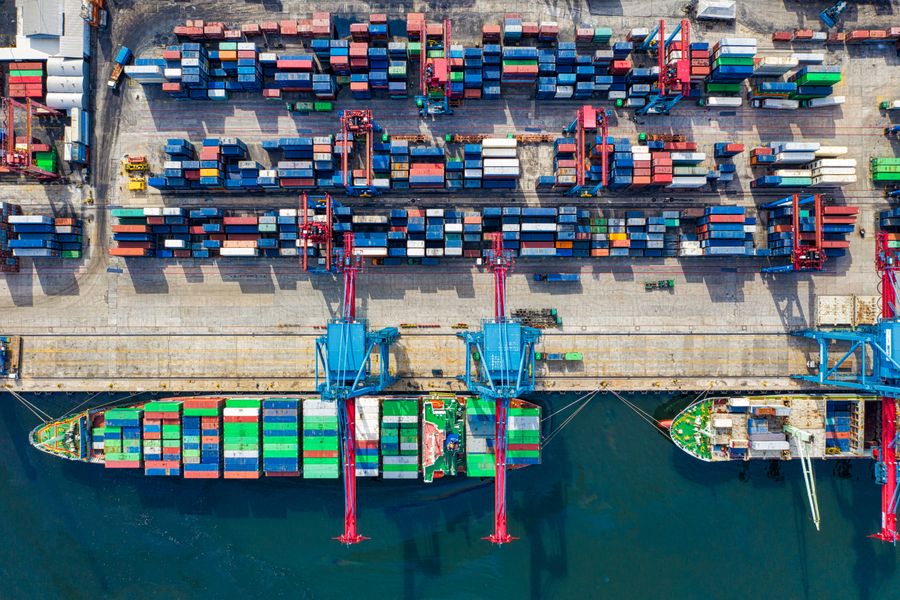 Aerial view of a container terminal with stacked containers reduced to coloured blocks