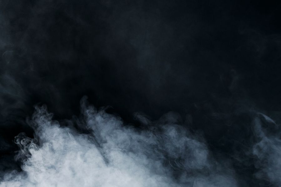 A low cloud of fine cool mist drifting across a dark background