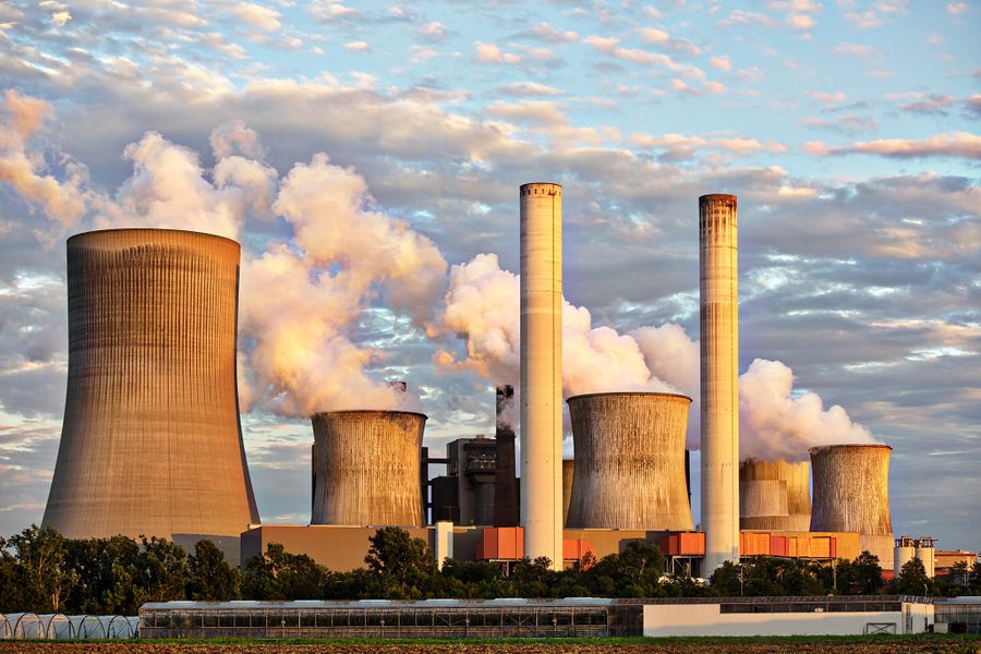Cooling towers releasing plumes of water vapour against an evening sky