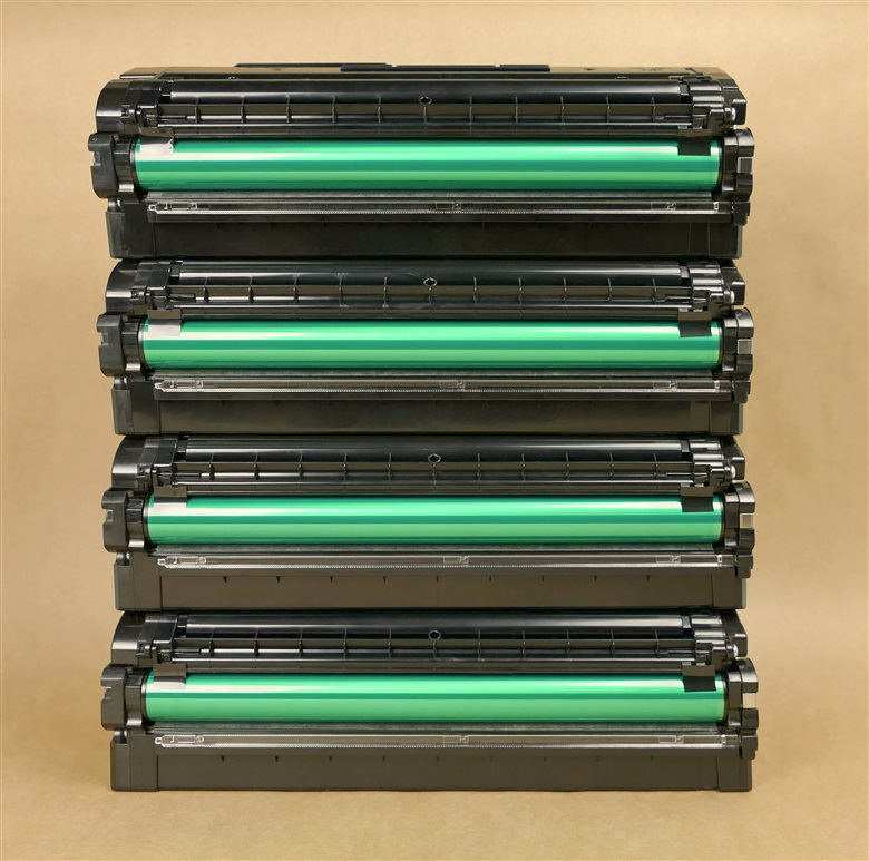Four laser toner cartridge units with green photoconductor drums exposed
