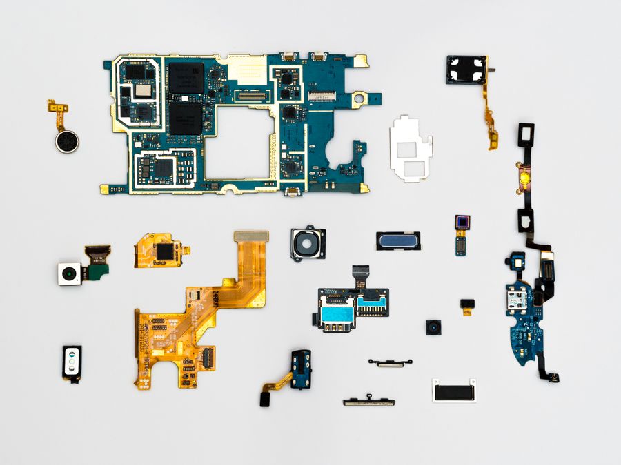 Circuit board and small electronic components laid out on a white surface