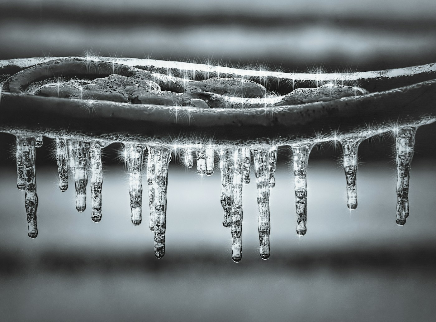 Icicles hanging in a row beneath a cast iron edge
