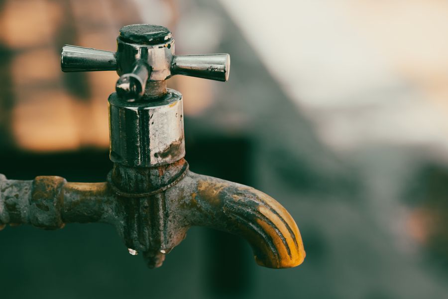 Mineral scale crusting an old metal tap spout