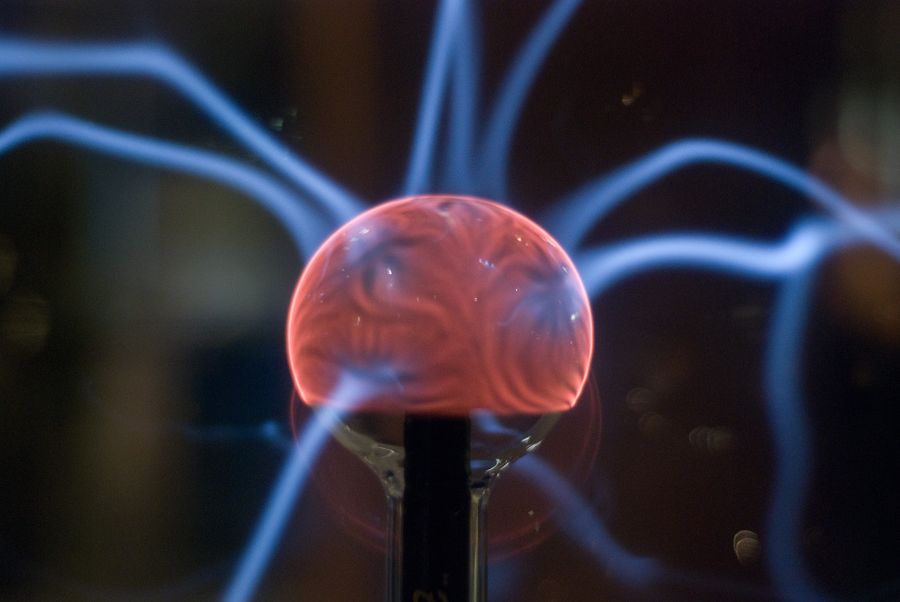 A plasma ball with electric arcs reaching out in the dark