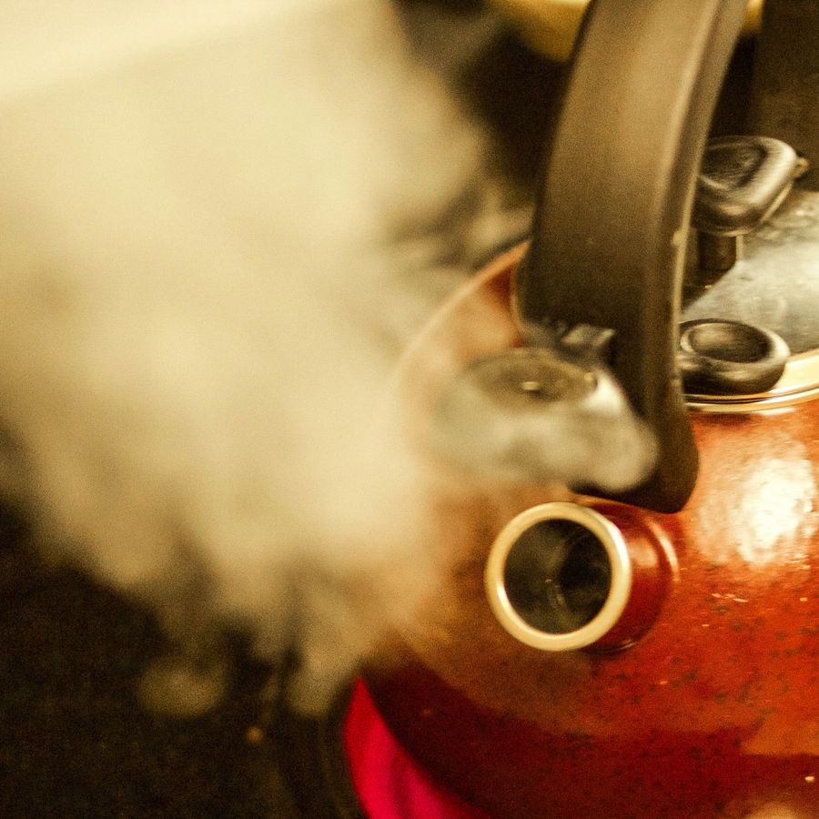 Steam venting from the spout of a copper kettle