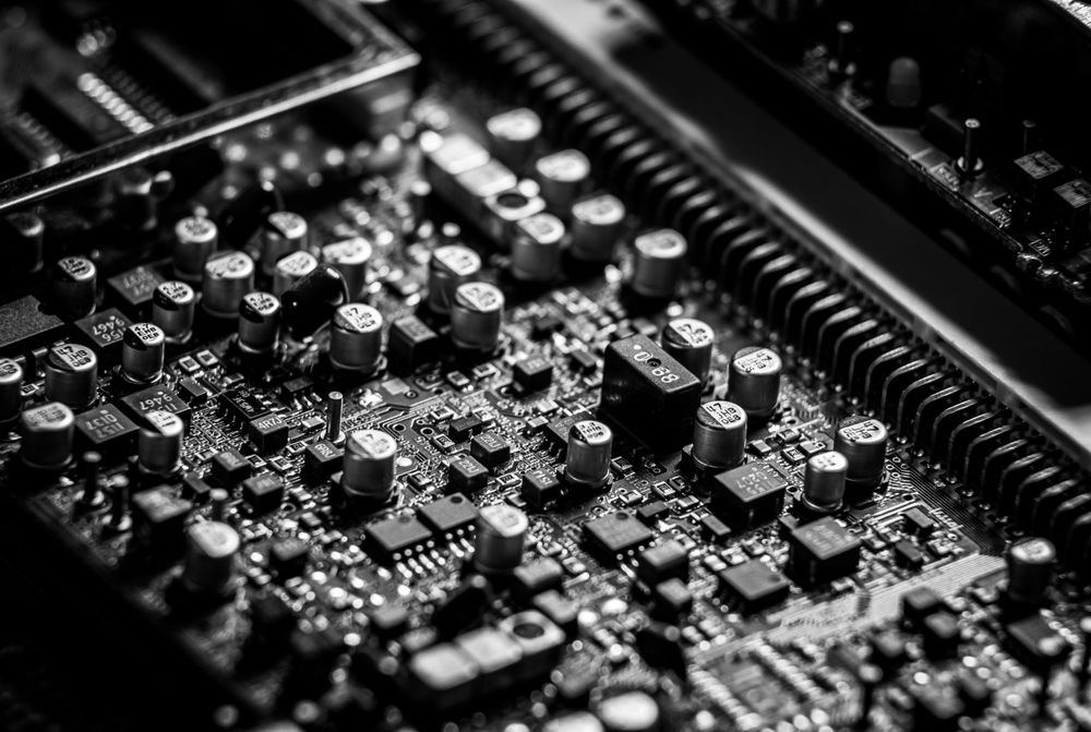 A densely populated circuit board of surface-mount components in black and white