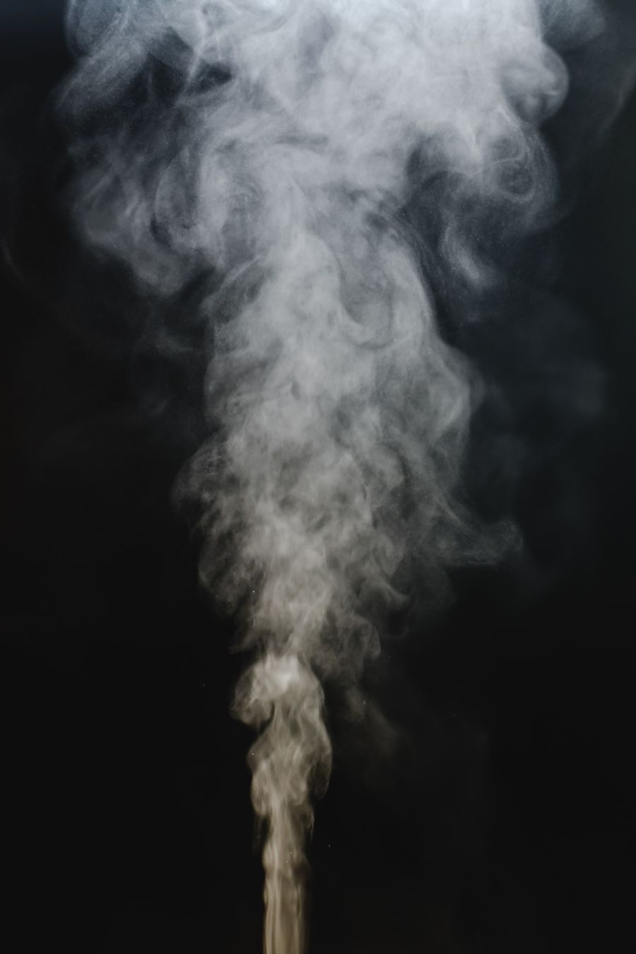 A rising plume of water vapour against a dark background